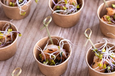 Plateau repas composé de légumes colorés, viande, riz et accompagnements, présenté sur une table en bois clair.