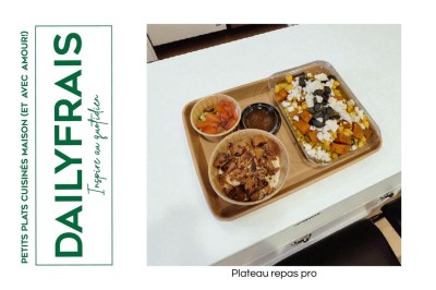 Plateau repas composé de légumes colorés, viande, riz et accompagnements, présenté sur une table en bois clair.