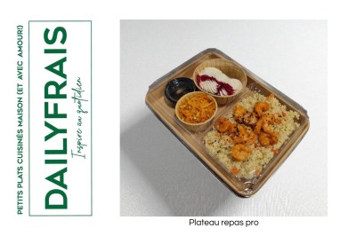 Plateau repas composé de légumes colorés, viande, riz et accompagnements, présenté sur une table en bois clair.