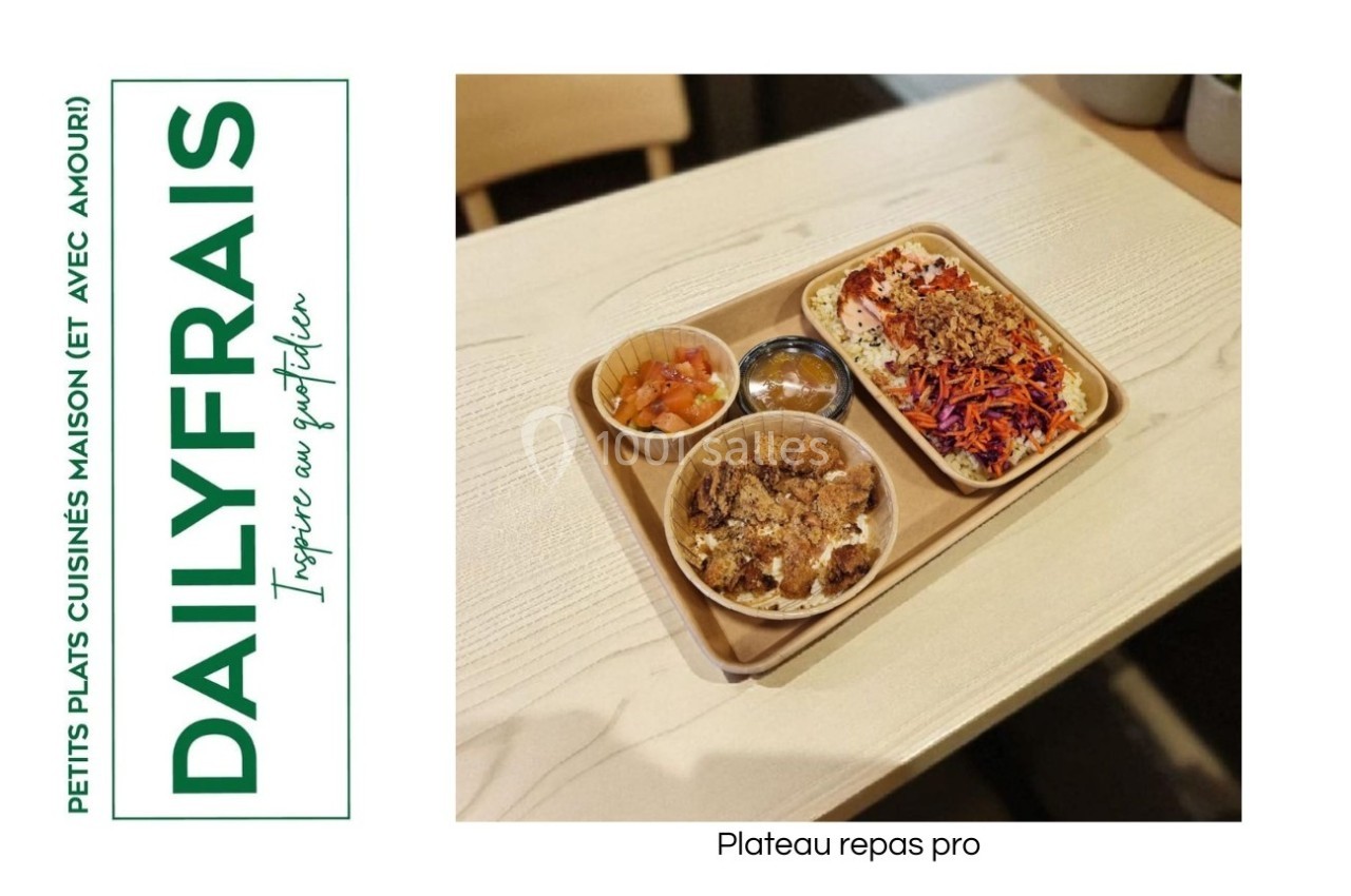 Plateau repas composé de légumes colorés, viande, riz et accompagnements, présenté sur une table en bois clair.