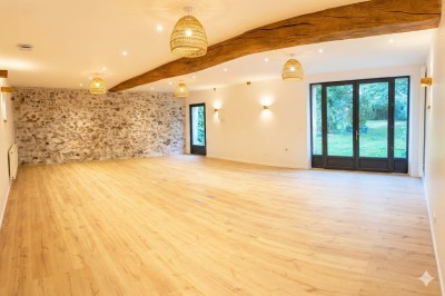 Miniature Location salle Verdelot (Seine-et-Marne) - Maison la Girouette #3 Salle lumineuse avec parquet en bois clair, murs blancs, poutres apparentes et grandes fenêtres donnant sur un jardin.