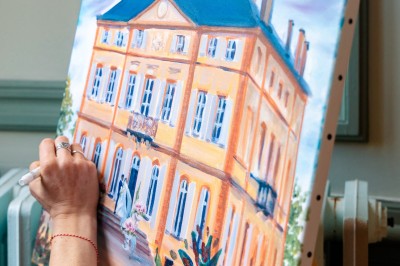 Un couple en tenue de mariage se tient devant une grande table décorée, avec un manoir en arrière-plan.