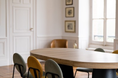 Un couple en tenue de mariage se tient devant une grande table décorée, avec un manoir en arrière-plan.