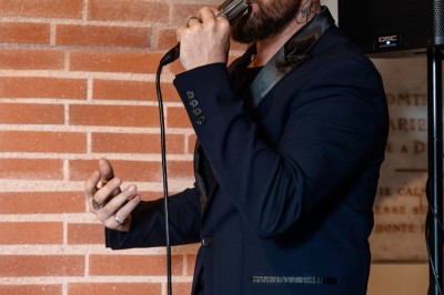 Un couple en tenue de mariage se tient devant une grande table décorée, avec un manoir en arrière-plan.