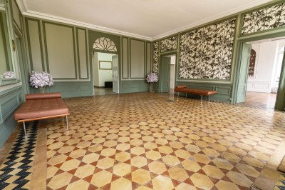 Un couple en tenue de mariage se tient devant une grande table décorée, avec un manoir en arrière-plan.