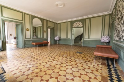 Un couple en tenue de mariage se tient devant une grande table décorée, avec un manoir en arrière-plan.