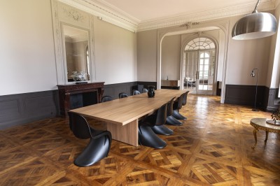 Un couple en tenue de mariage se tient devant une grande table décorée, avec un manoir en arrière-plan.