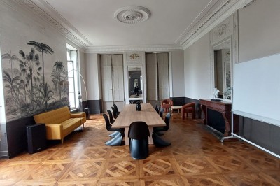 Un couple en tenue de mariage se tient devant une grande table décorée, avec un manoir en arrière-plan.
