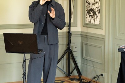 Un couple en tenue de mariage se tient devant une grande table décorée, avec un manoir en arrière-plan.