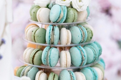 Un couple en tenue de mariage se tient devant une grande table décorée, avec un manoir en arrière-plan.