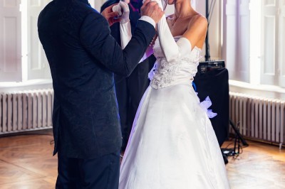 Tente blanche montée sur une pelouse, entourée de personnes et de tables, dans une cour avec bâtiments en arrière-plan.