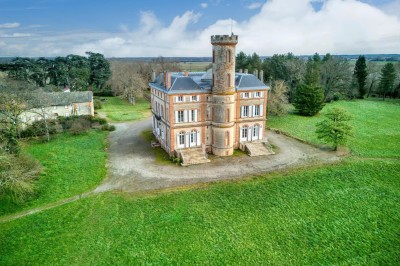 Tente blanche montée sur une pelouse, entourée de personnes et de tables, dans une cour avec bâtiments en arrière-plan.