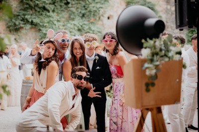 Appareil photo sur trépied en bois avec lampe circulaire, installé dans un jardin verdoyant.