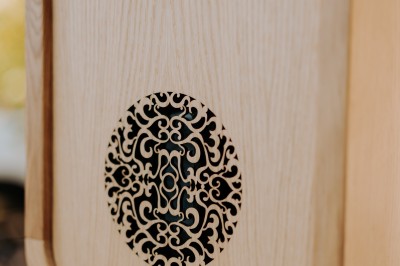 Boîtier en bois sur trépied avec un écran et un objectif circulaire, utilisé en extérieur.