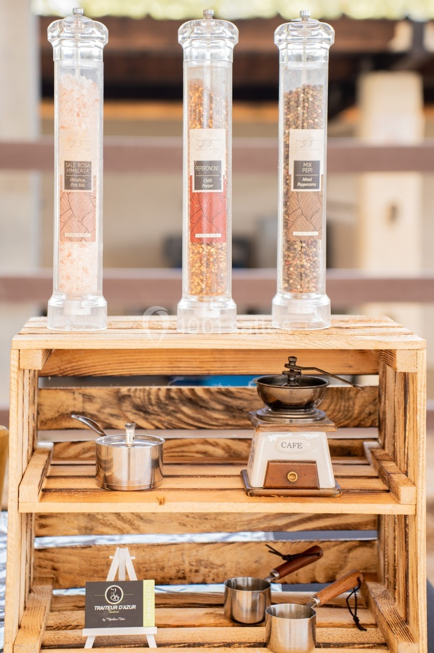 Trois moulins à épices sur une étagère en bois avec une balance vintage et des ustensiles de cuisine en métal.