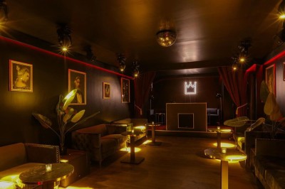Miniature Location salle Paris 9 (Paris) - Chez Prince Pigalle #6 Façade d'un établissement avec une entrée vitrée, éclairée par une lumière rouge et une enseigne lumineuse bleue.