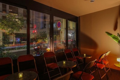 Façade d'un restaurant avec une enseigne lumineuse bleue et un intérieur éclairé par des lumières rouges.