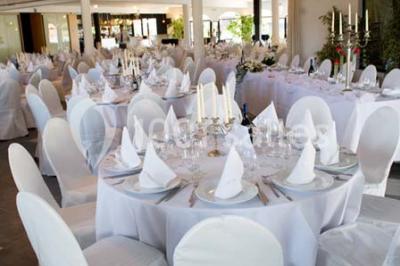 Piscine extérieure entourée de terrasses en bois et de chaises longues, devant une maison moderne sous un ciel dégagé.