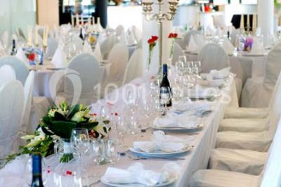 Piscine extérieure entourée de terrasses en bois et de chaises longues, devant une maison moderne sous un ciel dégagé.