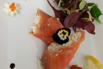 Filet de poisson nappé de sauce brune, accompagné de purée, lard croustillant et légumes sautés.