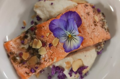 Filet de poisson nappé de sauce brune, accompagné de purée, lard croustillant et légumes sautés.