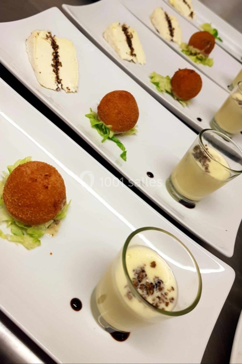 Assiettes dressées avec croquettes, mousse en verrine et tranche de fromage, décorées de salade et sauce balsamique.