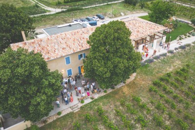 Bâtiment moderne éclairé en soirée, entouré d'arbres et d'un jardin sombre sous un ciel crépusculaire.