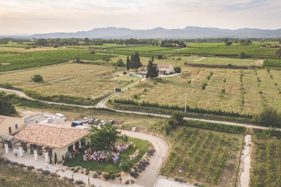 Bâtiment moderne éclairé en soirée, entouré d'arbres et d'un jardin sombre sous un ciel crépusculaire.