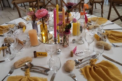 Assiette avec un morceau de viande nappé de sauce, purée, garniture de légumes et fleur comestible en décoration.
