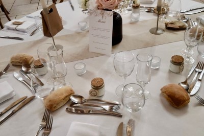 Assiette avec un morceau de viande nappé de sauce, purée, garniture de légumes et fleur comestible en décoration.
