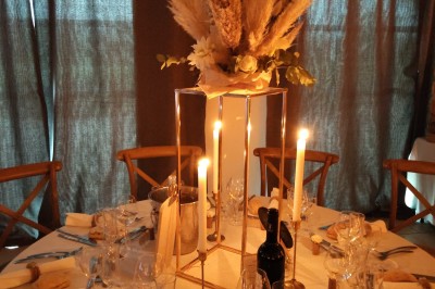 Assiette avec un morceau de viande nappé de sauce, purée, garniture de légumes et fleur comestible en décoration.