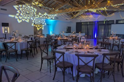 Assiette avec un morceau de viande nappé de sauce, purée, garniture de légumes et fleur comestible en décoration.