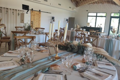 Assiette avec un morceau de viande nappé de sauce, purée, garniture de légumes et fleur comestible en décoration.