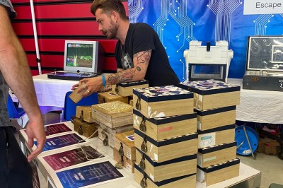 Des personnes tiennent un parachute coloré avec des trous, utilisé pour une activité de groupe en extérieur sur une pelouse.