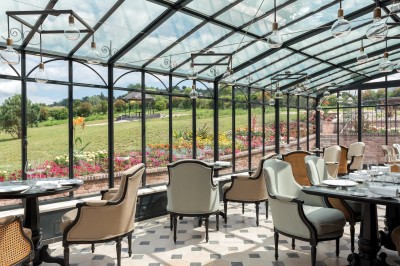 Quatre personnes jouent au padel sur un court extérieur avec vue sur des montagnes et un ciel dégagé.