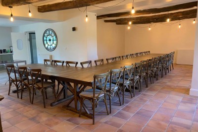 Chambre avec un lit double, murs verts, grande fenêtre donnant sur un paysage champêtre et éclairage doux.