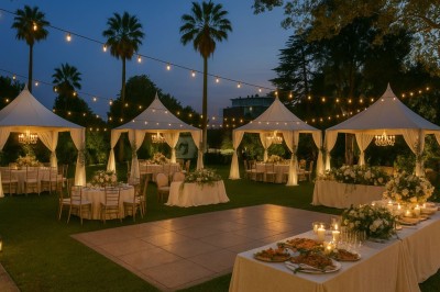 Coussin brodé ’Villa Alexandra’ au premier plan, banc en bois flou en arrière-plan dans un jardin ensoleillé.