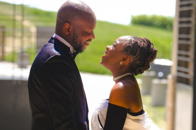 Un groupe de personnes souriantes posant ensemble devant un décor floral lumineux.