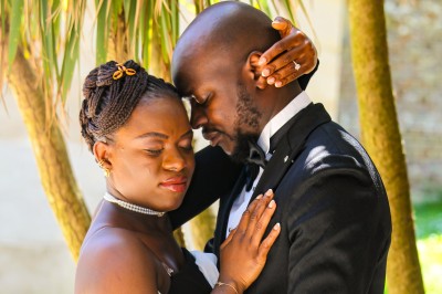 Un groupe de personnes souriantes posant ensemble devant un décor floral lumineux.