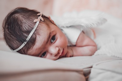 Un chanteur sur scène, vêtu de blanc, levant un bras sous des lumières de spectacle et un écran en arrière-plan.