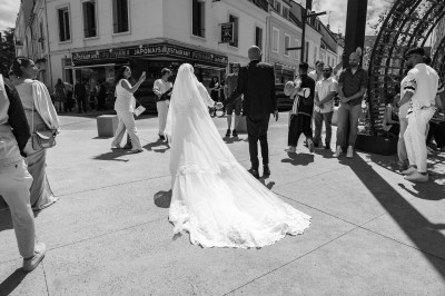 Un chanteur sur scène, vêtu de blanc, levant un bras sous des lumières de spectacle et un écran en arrière-plan.