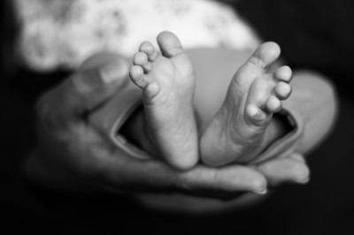 Un chanteur sur scène, vêtu de blanc, levant un bras sous des lumières de spectacle et un écran en arrière-plan.