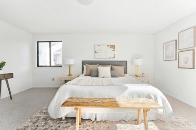 Un chanteur sur scène, vêtu de blanc, levant un bras sous des lumières de spectacle et un écran en arrière-plan.