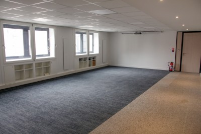 Miniature Location salle Montrouge (Hauts-de-Seine) - Confédération Musicale de France #6 Salle de réunion lumineuse avec tables en bois, chaises noires, écran de projection et fenêtres.