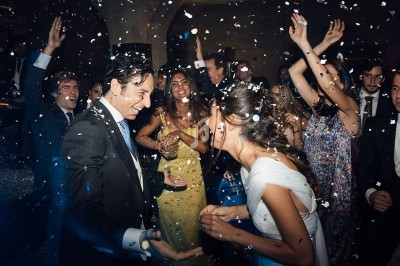 Groupe de personnes dansant et célébrant sous des confettis lors d'une fête en soirée.