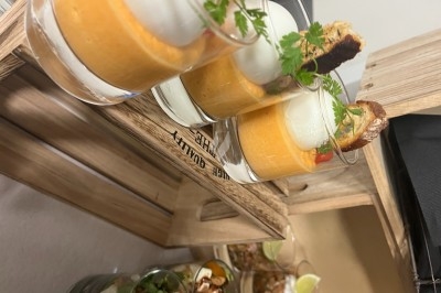 Verrines de velouté orange surmontées de mousse blanche, décorées de croûtons et de brins de persil.