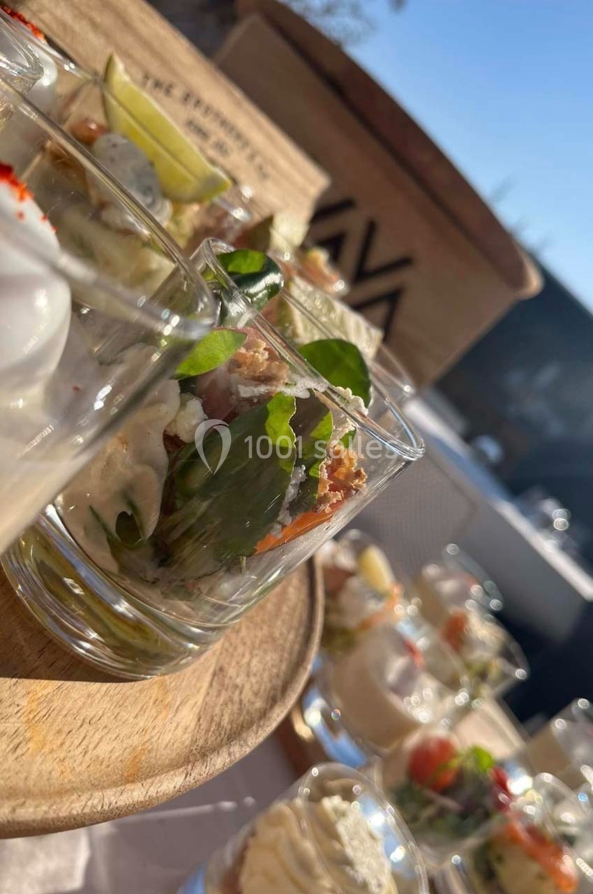 Plateau de verrines variées avec des ingrédients frais, présenté en extérieur sous une lumière naturelle.