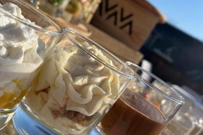 Plateau en bois avec fromages variés, fraises tranchées, noix concassées et herbes fraîches, près d'une fenêtre.