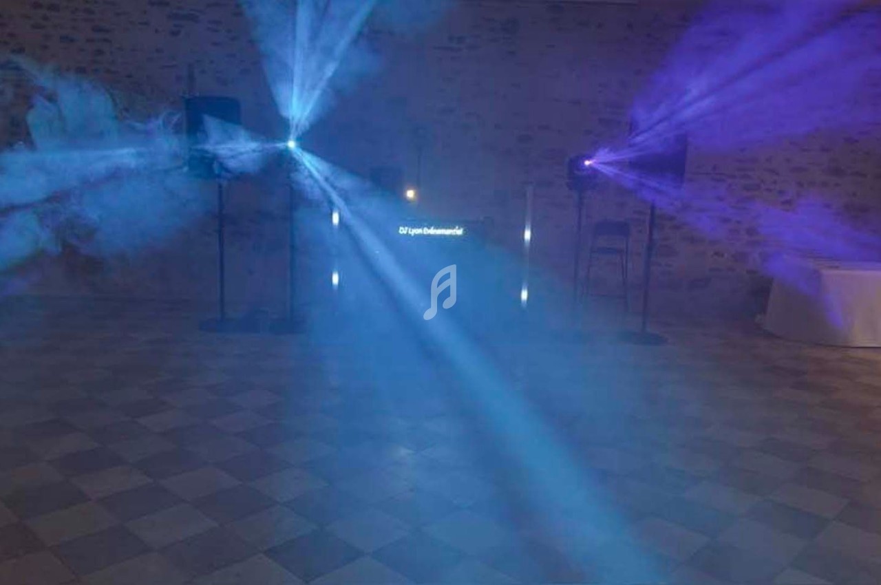 Jeux de lumières colorées projetés dans une salle avec sol en carreaux et murs en pierre.