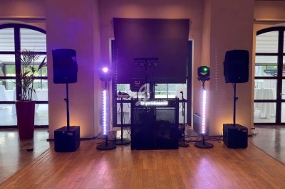 Jeux de lumières colorées projetés dans une salle avec sol en carreaux et murs en pierre.